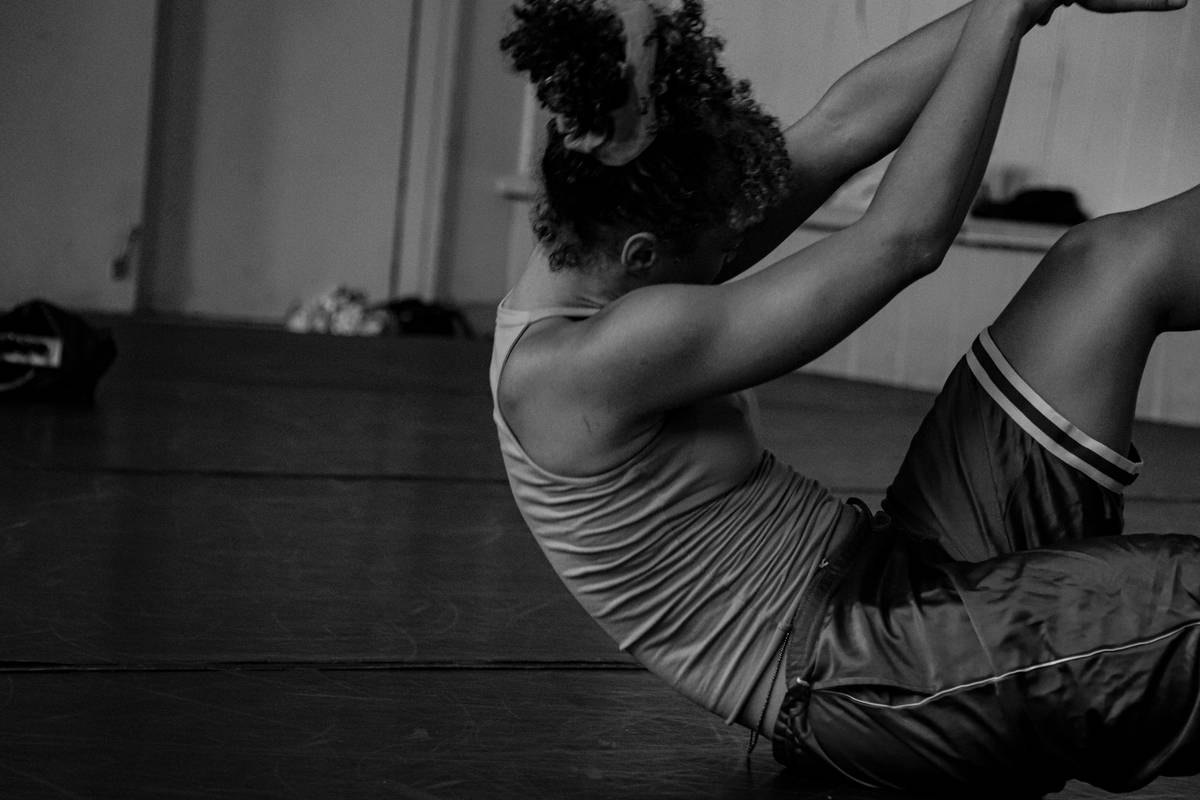 Woman performing core shaping workout in Pilates stance on mat